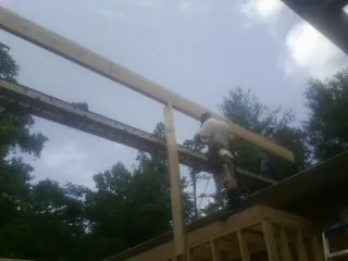 Carpenter setting a ridge beam over a new addition frame — Ice Dam Removal by Roofing Brothers in Mc Henry