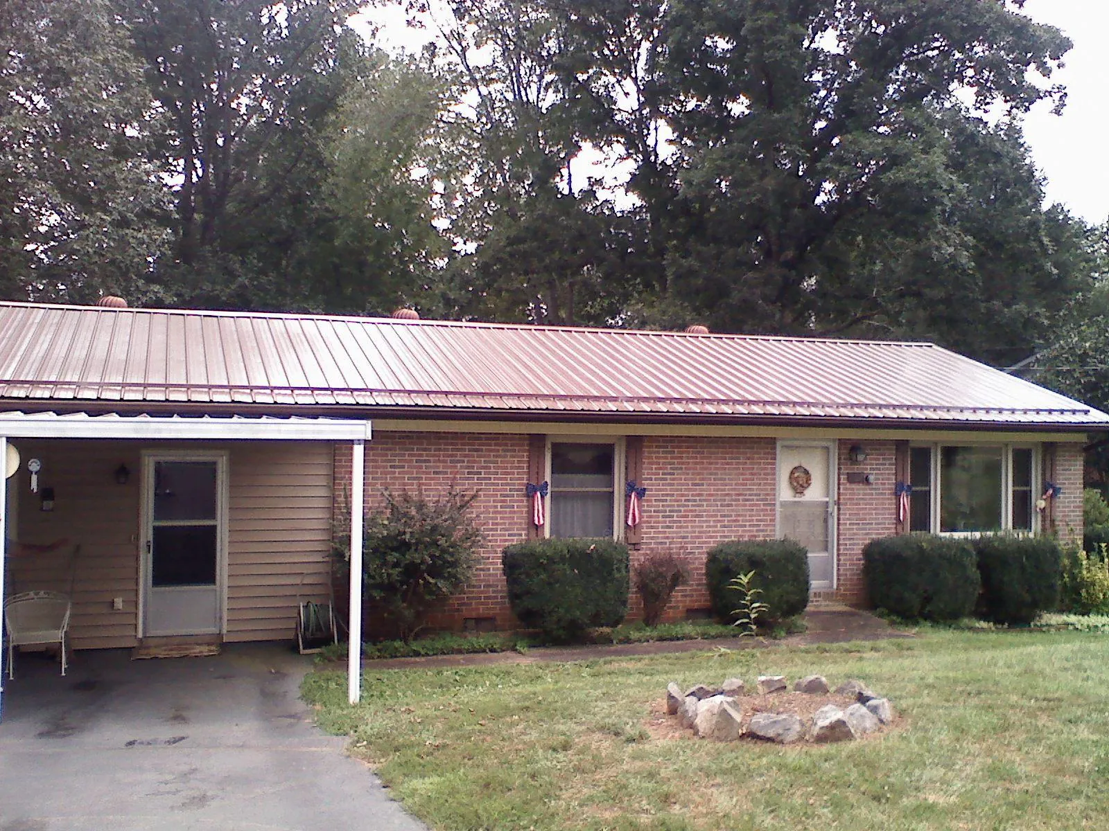 Bronze metal roof and carport on a brick ranch home — Roof Repair work by our crew in Mc Henry